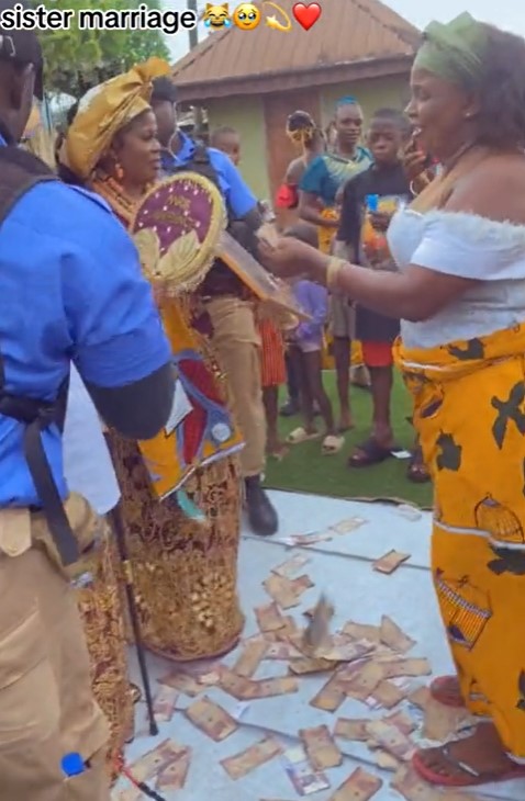 Lady is astonished as her boyfriend's mother sprays bundles of naira notes at her sister's wedding (VIDEO)