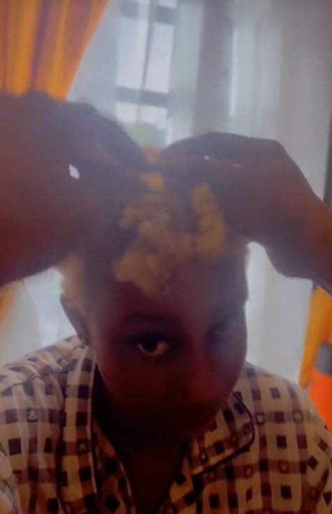 Nigerian man goes the extra mile as he shaves lady's coloured hair (VIDEO)