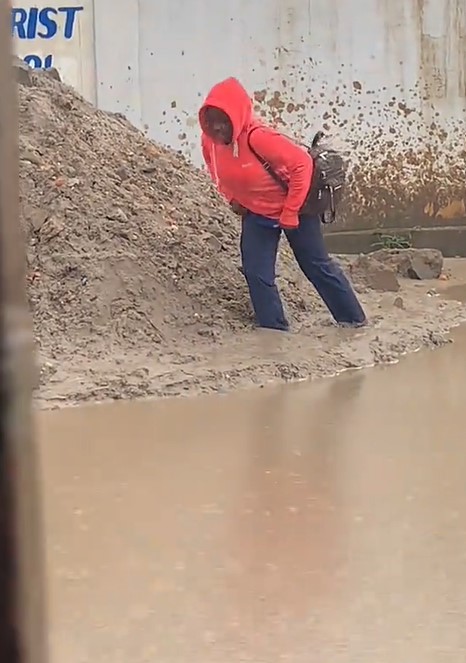 Lady gets stúck in mud, loses slipper while avoiding muddy water on street (WATCH)